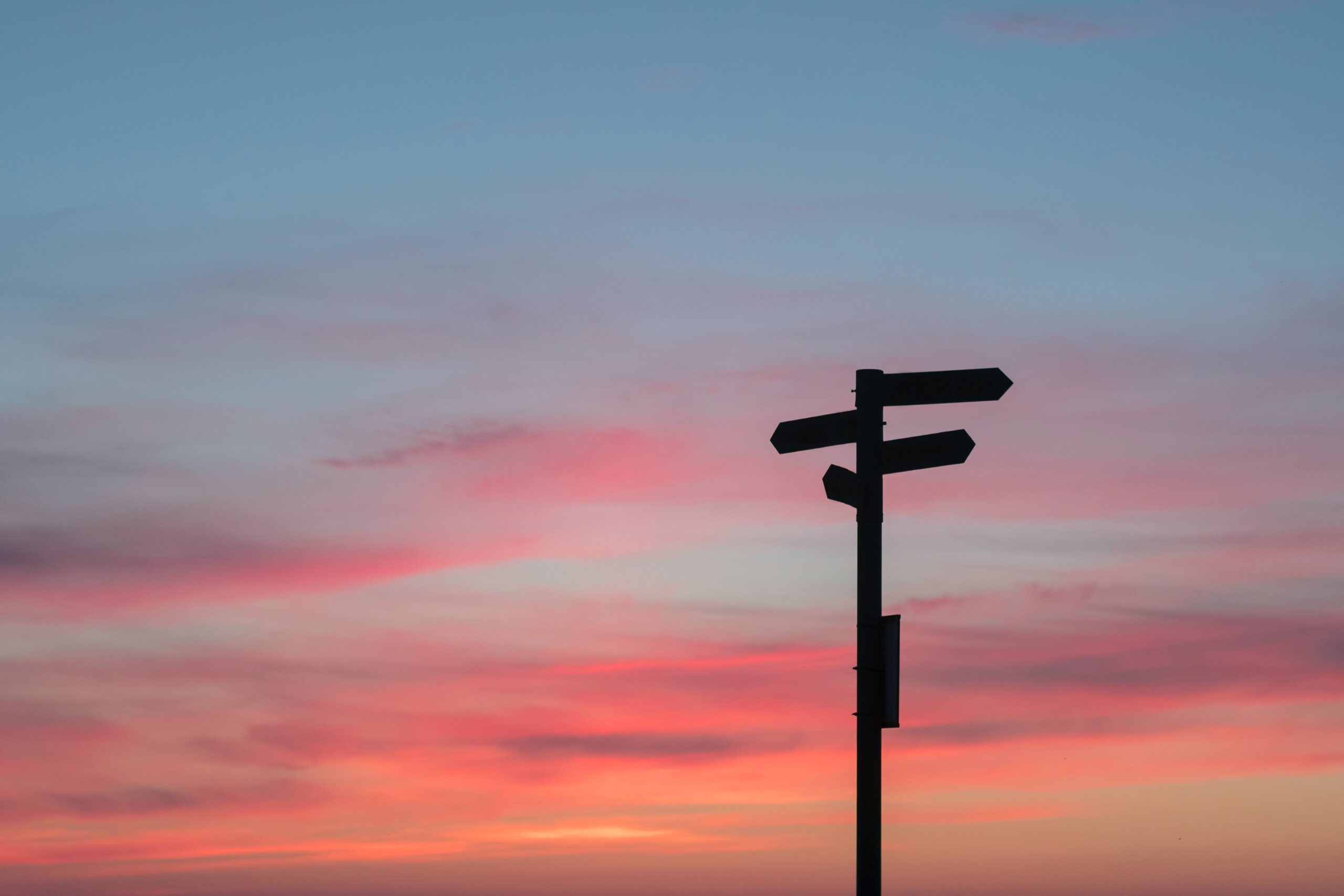 silhouette sign post with sunset or sunrise decisions planning 2021