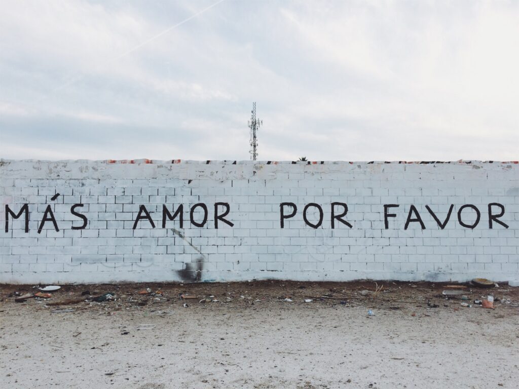 Mas amor por favor more love please written on the wall