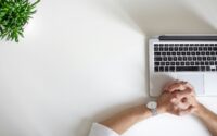 waiting by a computer hands next to a laptop