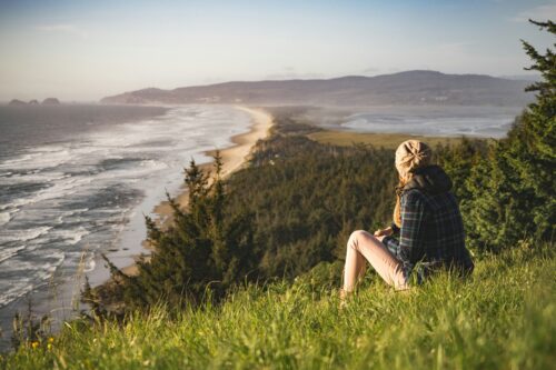 midlife woman sitting in nature looking at the sea