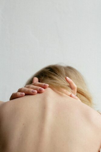 white woman with blond hair with head in hands and feeling tension, worry tightness and fear