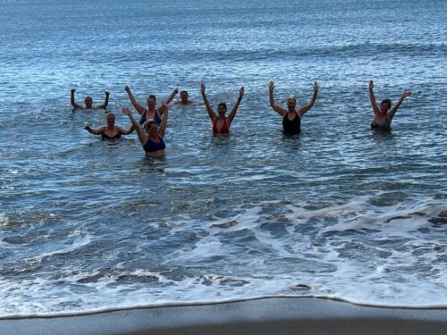 group of midlife expats cold water swimming in costa del sol beach
