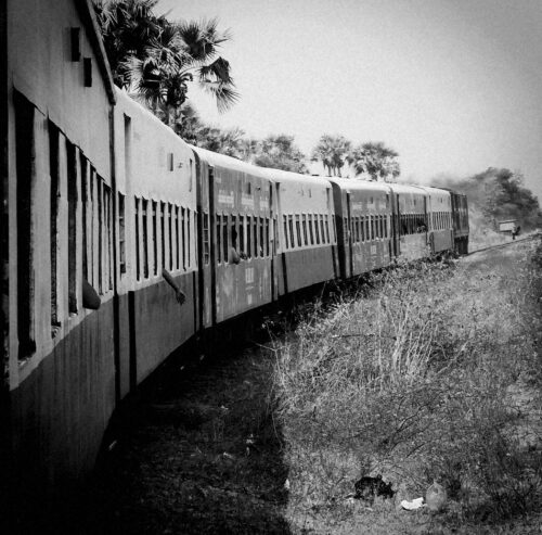 train rumbling along the tracks in black and white